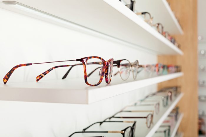 Fashionable corrective eye glasses on a shelf in optical store