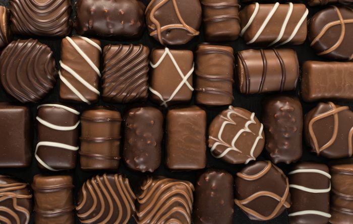 Beautiful Creative Chocolate Sweets on Natural Black Stone Background. Mix of Chocolates Top View and Flat Lay