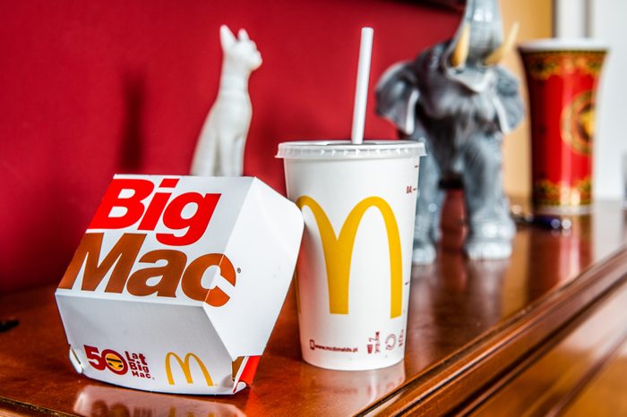 Warsaw, Poland, July 22, 2018 McDonald's Big Mac with two 100% pure beef patties and sauce sandwiched between sesame seed bun, with refreshing Coca-Cola Coke, big yellow McDonald's M sign, logo on cup