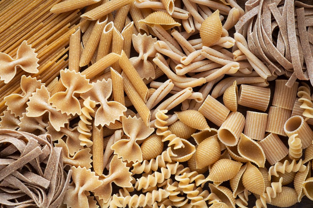 Variety of types and shapes of dry wholemeal pasta