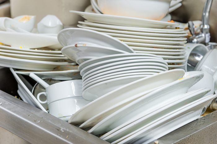 The plate dishes in the kitchen waiting for cleaners in sink