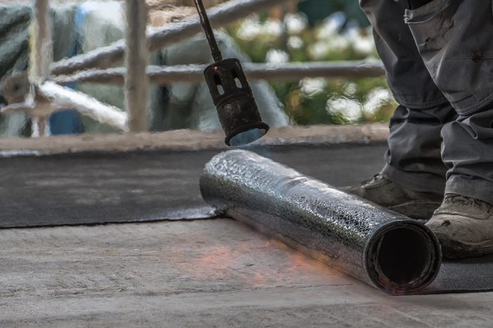 Installation by heating and melting of bitumen rolls by torch to flame while sealing the substrate against ascending moisture. Professional installation of the waterproofing on the concrete foundation