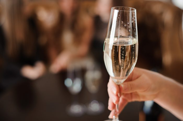glass of champagne on the background of friends at a party