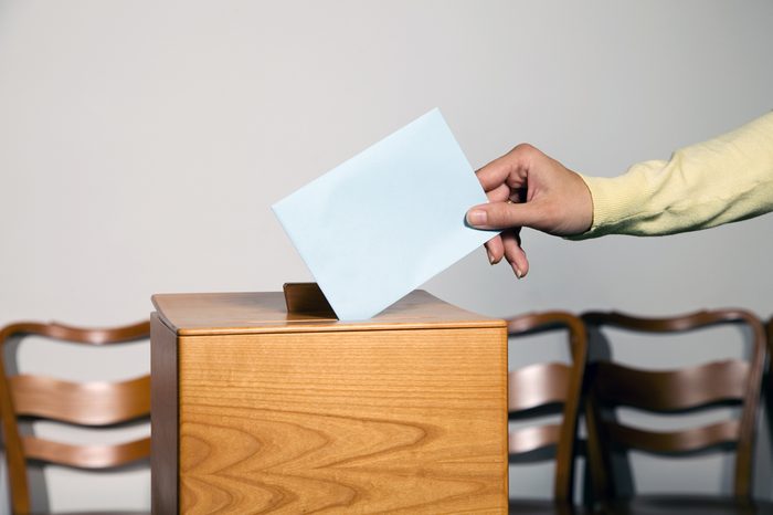 A young woman in an election shall deliver their vote. Ballot at the polling station.
