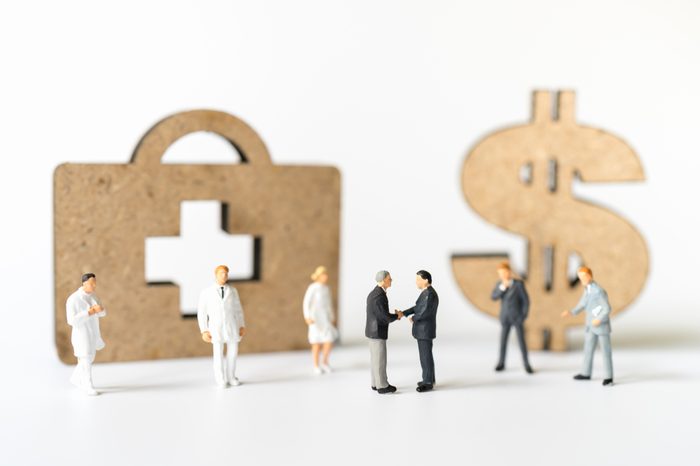 Miniature people, Business man dealing successful contract with doctor and nurse on white background. Health care, life insurance travel hospitality concept.