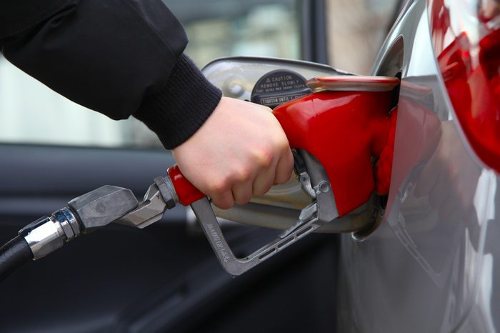 Gas pump refilling automobile fuel. Shallow focus.