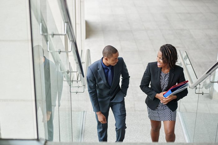 African-American business couple walking up the stairs and talking