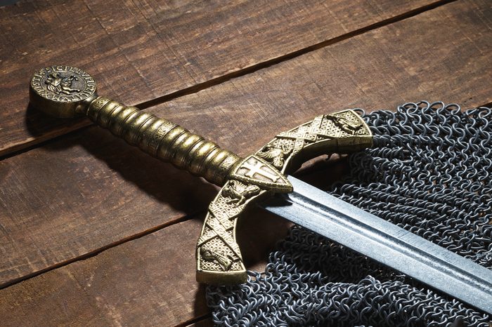 Ancient sword with the bronze handhold on a beautiful background