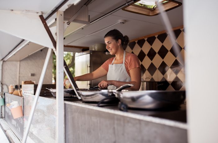 street sale, eating and people concept - happy chef or seller cooking at food truck