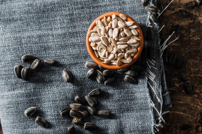 Fresh Sunflower seed and oil. Shelled sunflower seeds in wood bowl. Sunflower close-up