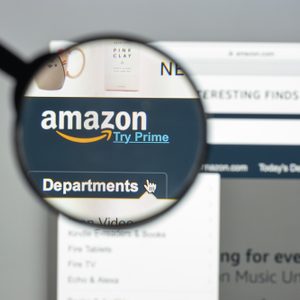 A magnifying glass enlarges the Amazon logo and 