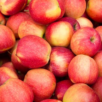 Red apples fill the frame, displaying vibrant colors in a close-up view.