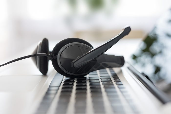 Communication support, call center and customer service help desk. VOIP headset on laptop computer keyboard.