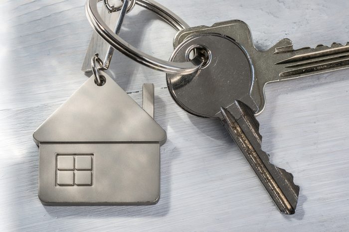 Real estate concept - Keys on white wooden sunny background