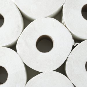 Rolls of toilet paper are stacked in a close cluster, viewed from above.