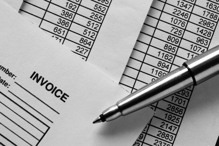 Close up Shot of Conceptual Silver Ballpoint Pen on Top of Invoice Papers Printed with Figures.
