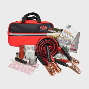 Emergency car kit displayed, showing jumper cables, a flashlight, a poncho, bandages, instruction booklets, and a red carrying case; items organized neatly.