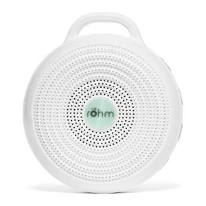 Round white noise machine emits sound, encased in perforated circles with central text 