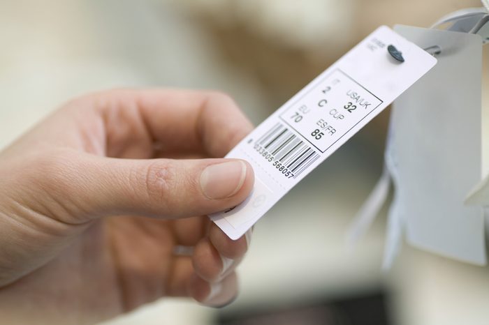 Closeup of woman's hands holding clothes tag in store
