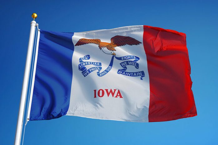 Iowa (U.S. state) flag waving against clear blue sky, close up, isolated with clipping path mask alpha channel transparency, perfect for film, news, composition