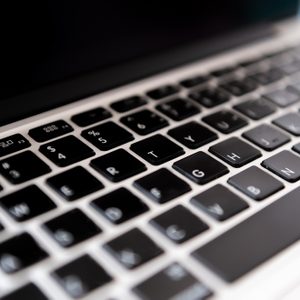 Laptop keyboard, viewed from an angle, with keys visible in close-up, against a blurred background.