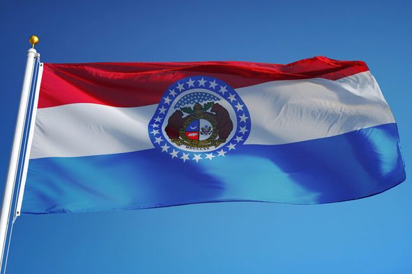 Missouri (U.S. state) flag waving against clear blue sky, close up, isolated with clipping path mask alpha channel transparency, perfect for film, news, composition