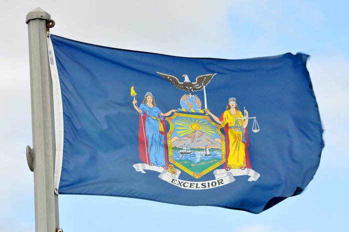Flag of New York State in blue sky background