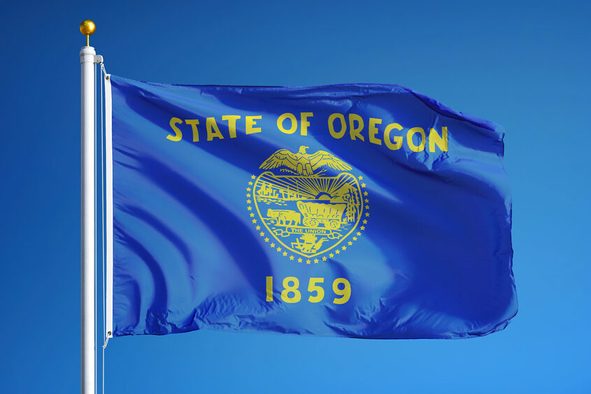 Oregon (U.S. state) flag waving against clear blue sky, close up, isolated with clipping path mask alpha channel transparency, perfect for film, news, composition