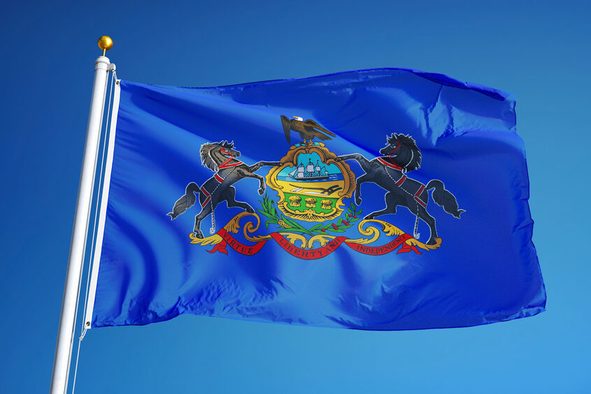 Pennsylvania (U.S. state) flag waving against clear blue sky, close up, isolated with clipping path mask alpha channel transparency, perfect for film, news, composition