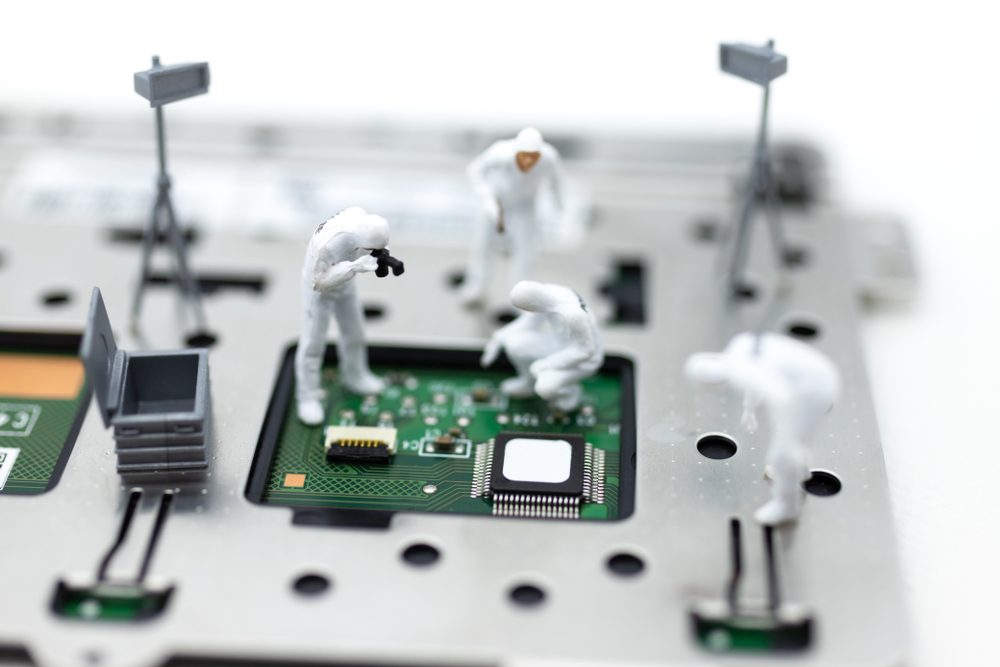 Miniature figures examine a microchip, representing a technological investigation, surrounded by circuit board elements and tripods, creating a detailed, imaginative scene.