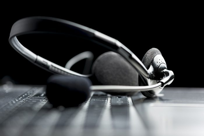 Headset lying on a laptop computer keyboard conceptual of online communication or a call centre, low angle view