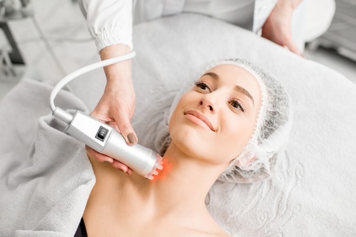 Young woman during a massage on the neck with professional tool at the medical center