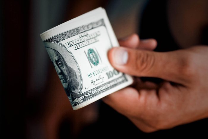 The man gives a pack of money