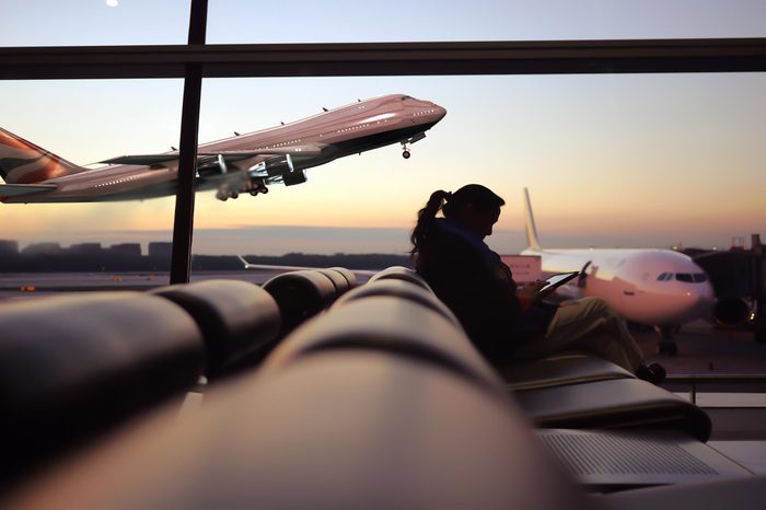 Woman playing smartphone at airport