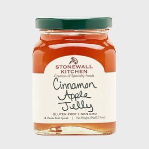 A jar of cinnamon apple jelly with a green lid, labeled 