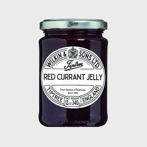 A jar holds red currant jelly, labeled 