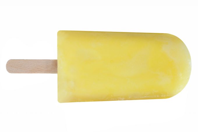 Yellow ice lolly over a white background