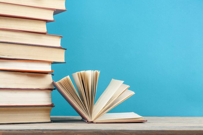 Open book, hardback books on wooden table. Education background. Back to school. Copy space for text