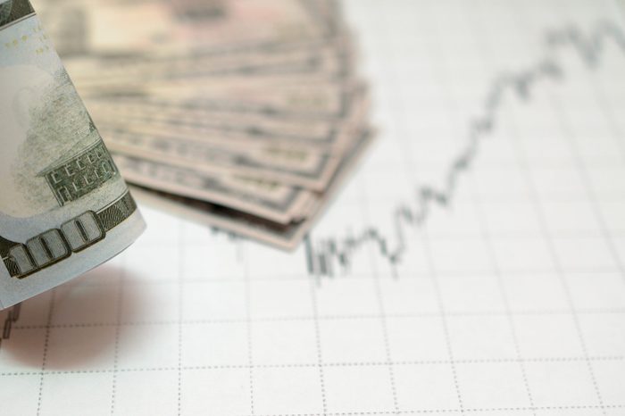 Money against the background of financial stock charts