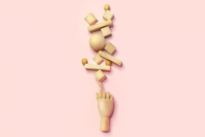 wooden hand balancing many different shapes and sizes blocks. multitasking concept.
