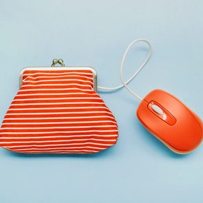 Red-striped coin purse connects to orange computer mouse on a light blue background.