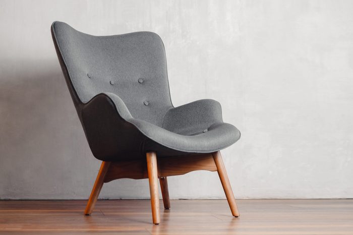 Gray chair in white concrete room for copy space. Concept of minimalism.
