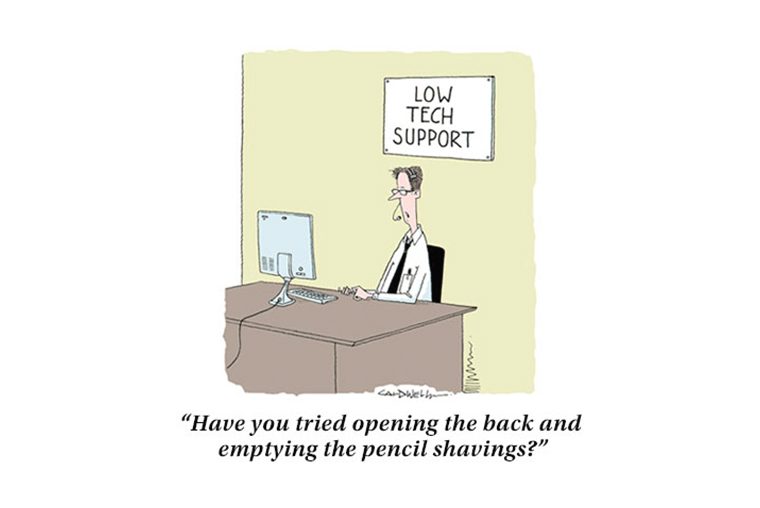 Man sits at a desk, typing on a computer labeled "Low Tech Support," with a humorous caption about pencil shavings.