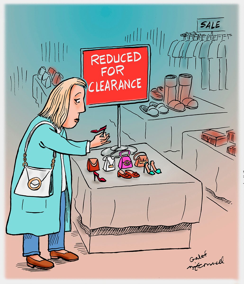 Shopper examines tiny shoes under a "Reduced for Clearance" sign in a store's sale section, surrounded by clothing racks and accessories.