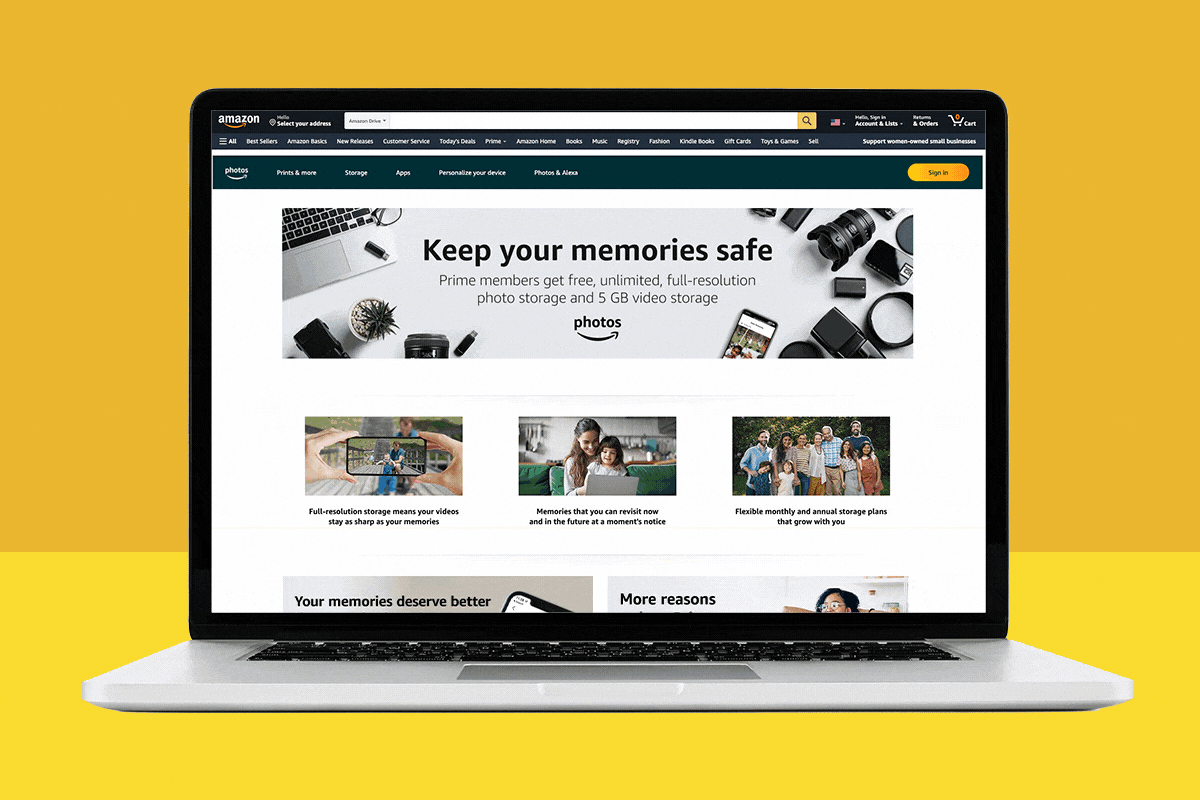 Laptop displaying Amazon Photos webpage, offering Prime members unlimited photo storage, against a solid yellow backdrop. Various photo-related icons and text are visible.