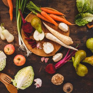 Autumn fruit and roots veggies background. Healthy, garden local produce. Rustic dark style. Horseradish, leeks, beetroot, parsley roots, celery plants, apple, pear.