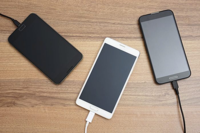 Mobile smart phones charging on wooden desk