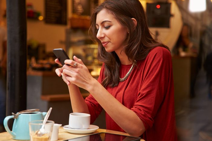 Woman Viewed Through Window Of CafÃ?Â¢?? Using Mobile Phone