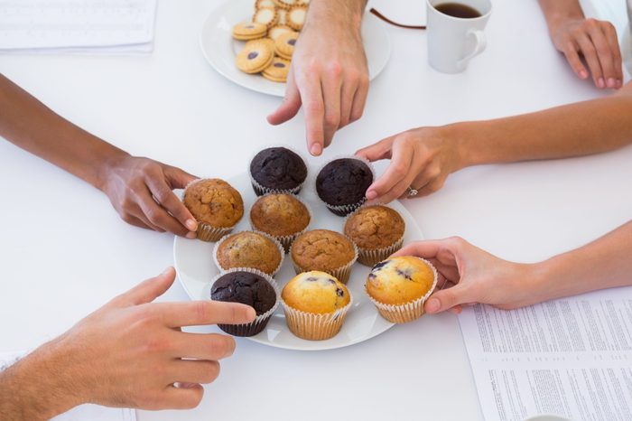 Hungry workers grabbing muffins in the office