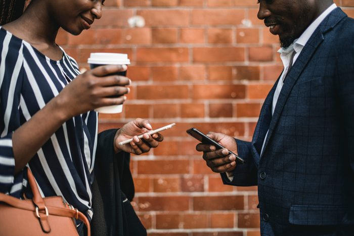 Two business people preoccupied by their phones
